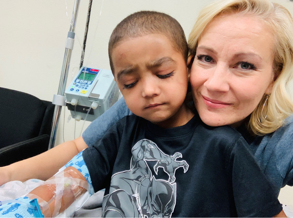 Child patient waits patiently during plasma infusion process with nurse.